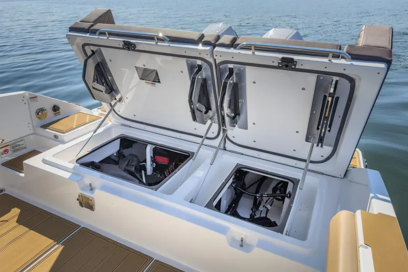 Slide: The Image of 2026 Monterey Elite 30 OB boat storage compartments open on deck by the water. - 36