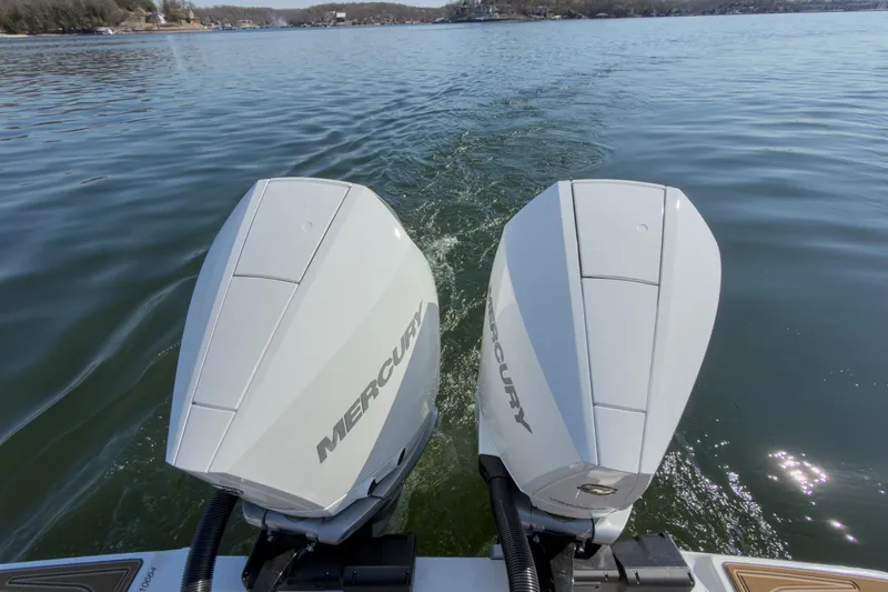 Slide: The Image of Twin Mercury outboard engines on a 2026 Monterey Elite 30 OB boat cruising on a lake. - 39