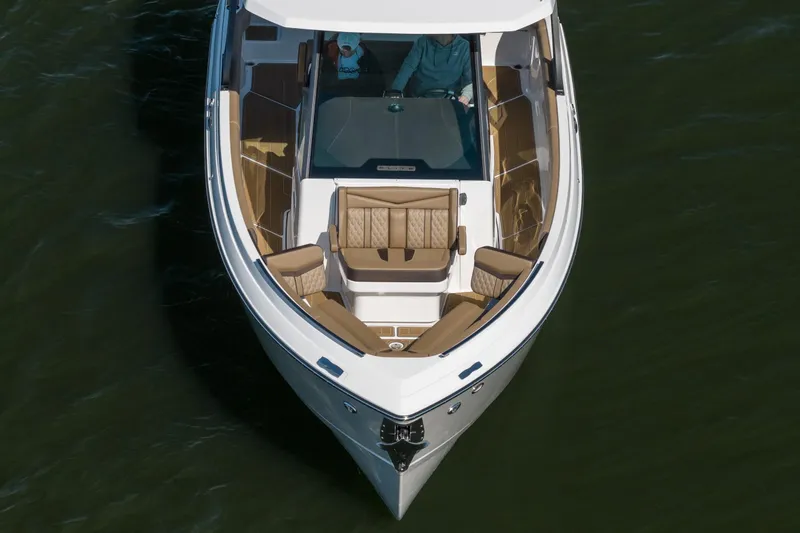 Slide: The Image of 2026 Monterey Elite 30 OB boat with luxurious seating on calm water. - 8