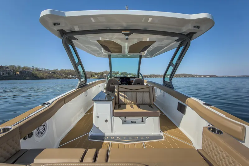 Slide: The Image of 2026 Monterey Elite 30 OB boat interior with luxurious seating on a calm lake. - 9