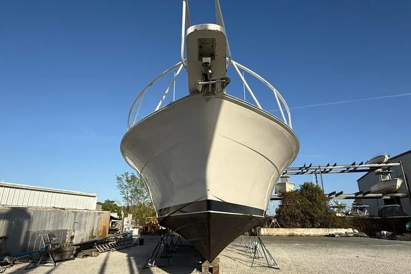 Slide: The Image of 1996 Bertram 50 Convertible boat on dry dock under clear blue sky. - 12