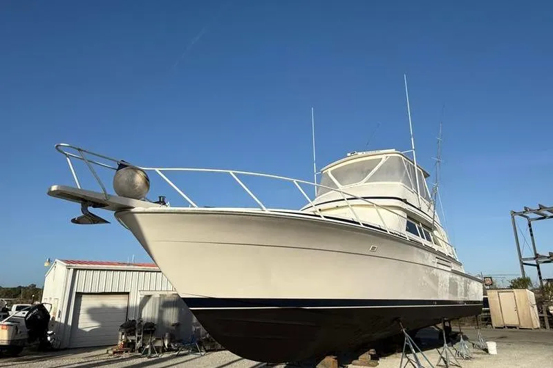 Slide: The Image of 1996 Bertram 50 Convertible yacht on dry dock under clear blue sky. - 13