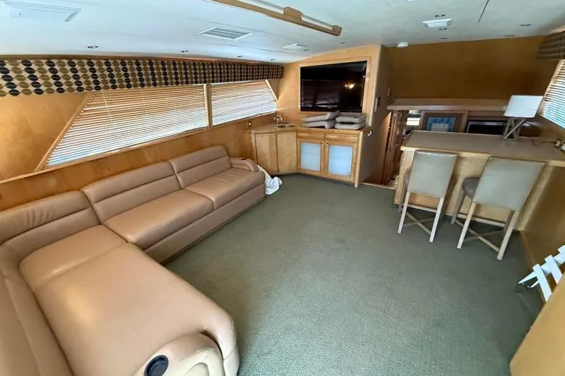 Slide: The Image of Interior of a 1996 Bertram 50 Convertible yacht with beige leather seating and bar area. - 15