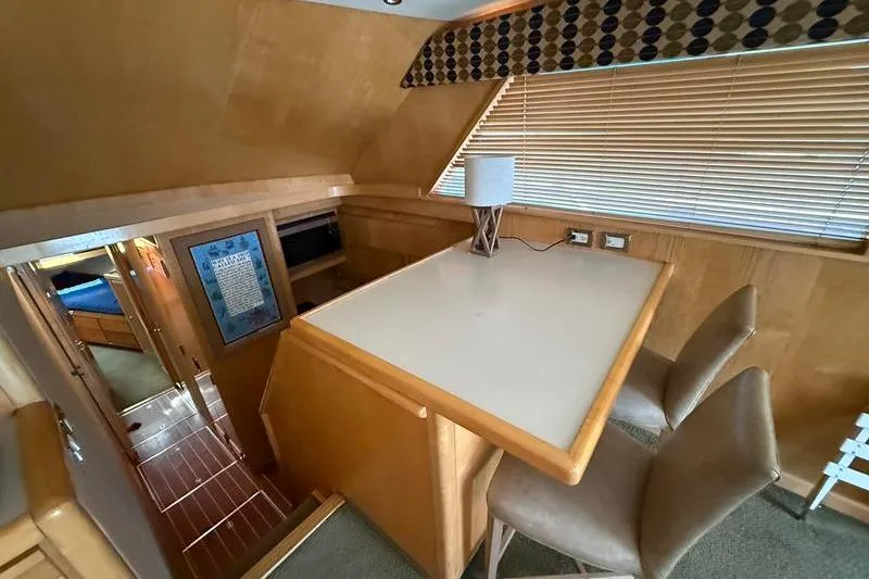 Slide: The Image of Interior of 1996 Bertram 50 Convertible yacht with dining area and wooden accents. - 18