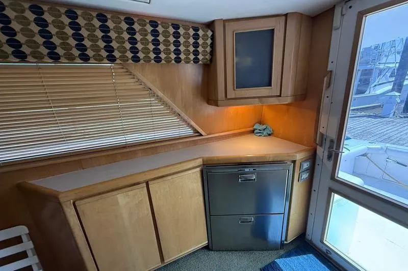 Slide: The Image of Interior of a 1996 Bertram 50 Convertible yacht with wooden cabinetry and modern appliances. - 19