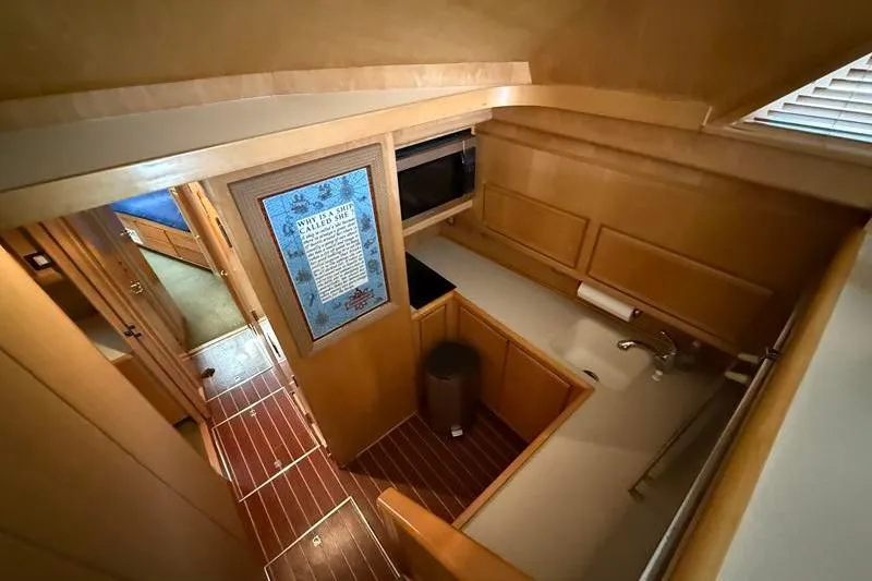 Slide: The Image of Interior of 1996 Bertram 50 Convertible yacht, featuring a compact kitchen area. - 20