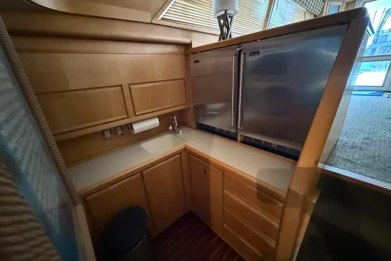 Slide: The Image of Compact kitchen area in a 1996 Bertram 50 Convertible yacht with stainless steel appliances. - 21