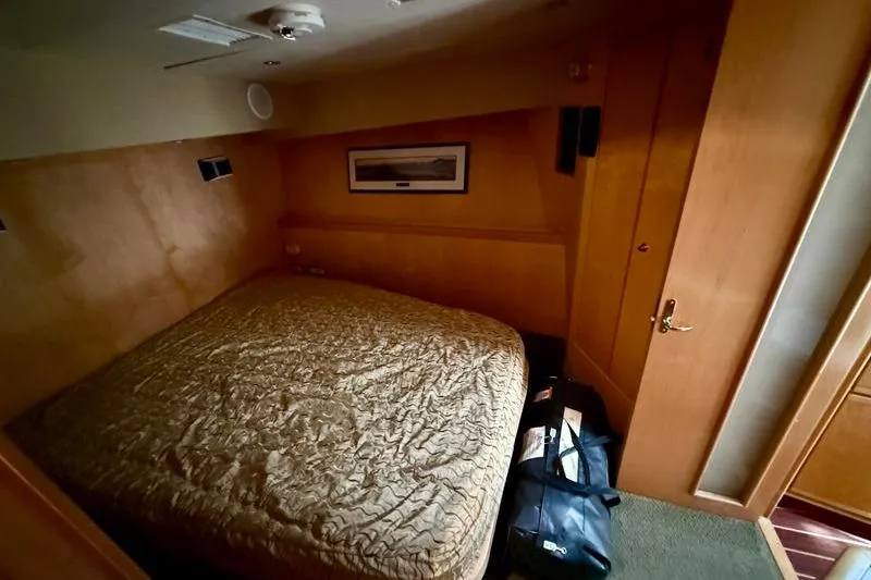 Slide: The Image of Cozy cabin interior of 1996 Bertram 50 Convertible yacht with bed and luggage. - 23