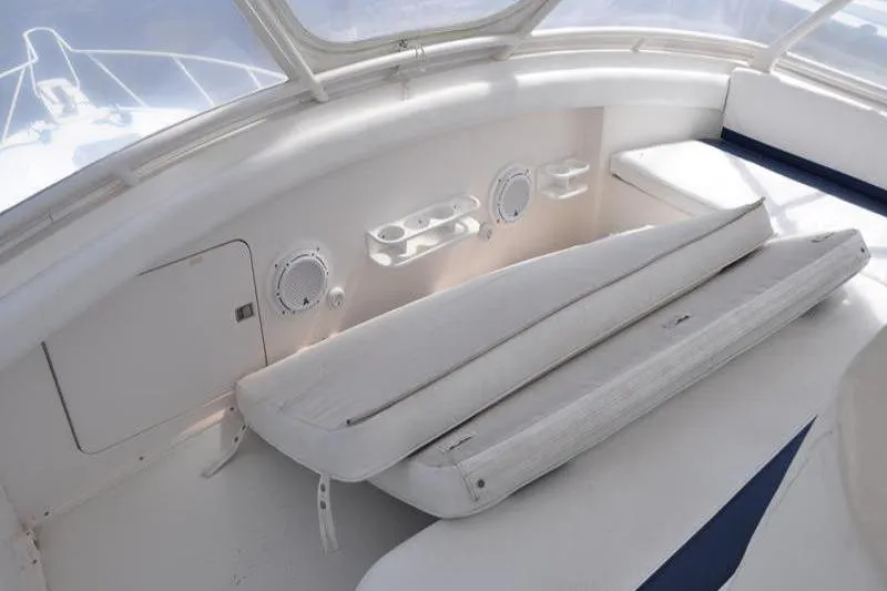 Slide: The Image of Interior of a 1996 Bertram 50 Convertible yacht with white seating and cup holders. - 29