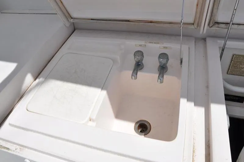 Slide: The Image of Sink area on a 1996 Bertram 50 Convertible yacht, featuring dual faucets. - 37
