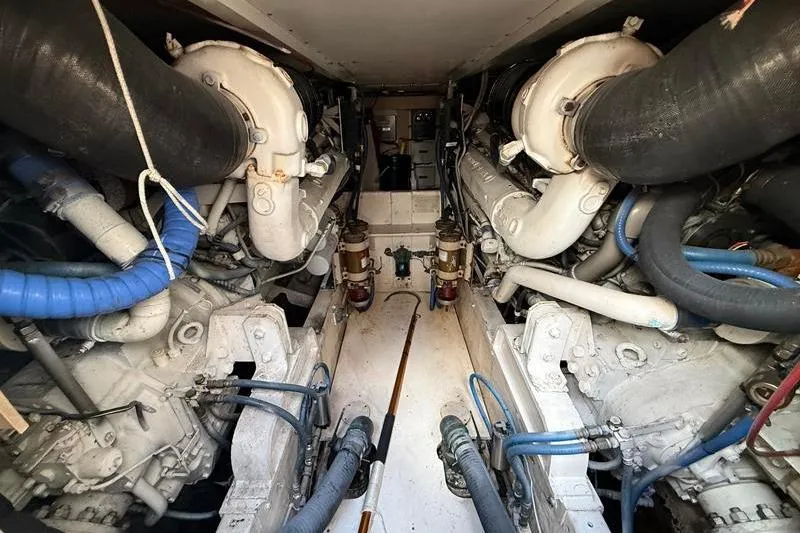 Slide: The Image of Engine room of a 1996 Bertram 50 Convertible yacht, showcasing dual engines and piping. - 39