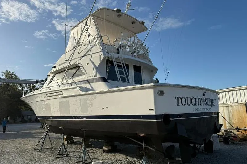 Slide: The Image of 1996 Bertram 50 Convertible yacht on dry dock under clear blue sky. - 6