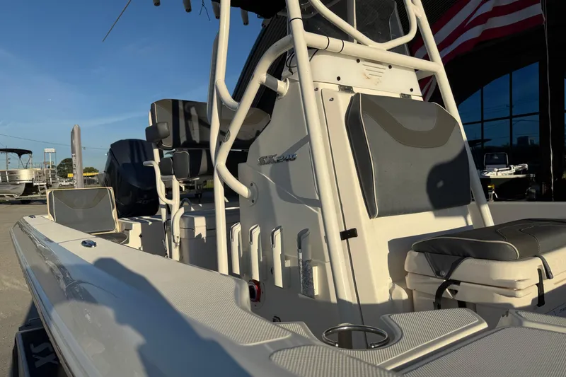 Slide: The Image of 2019 Skeeter SX240 boat interior with seating and console, parked outdoors. - 11