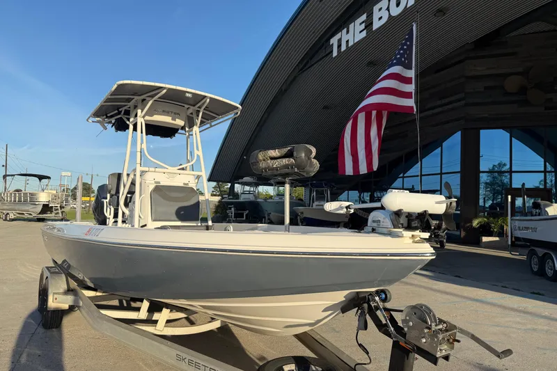 Slide: The Image of 2019 Skeeter SX240 boat on trailer with American flag, parked outside dealership. - 3