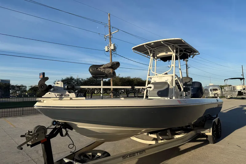 Slide: The Image of 2019 Skeeter SX240 boat on trailer, parked outdoors under clear blue sky. - 4