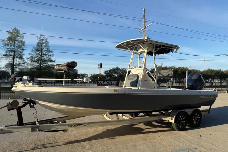 Slide: The Image of 2019 Skeeter SX240 boat on trailer, parked outdoors under clear sky. - 5