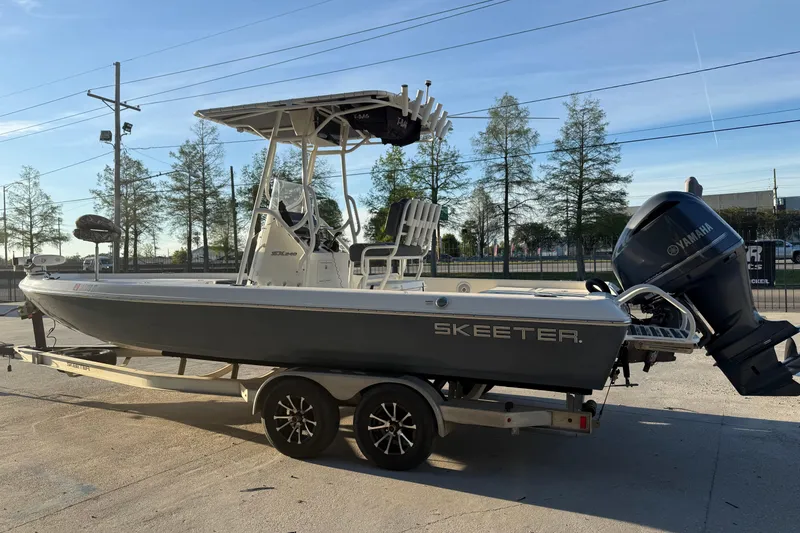 Slide: The Image of 2019 Skeeter SX240 boat on trailer with Yamaha outboard motor, parked outdoors. - 6