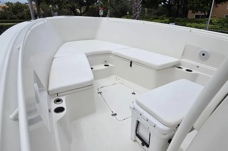 Slide: The Image of 2016 Sailfish 320 CC boat interior with white cushioned seating and cup holders. - 11