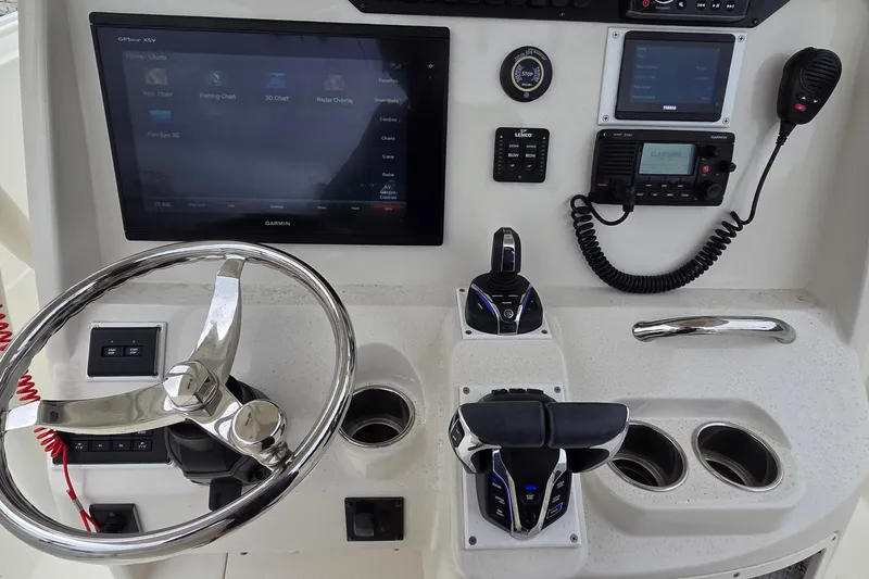 Slide: The Image of Control panel of a 2016 Sailfish 320 CC boat with steering wheel and navigation equipment. - 12