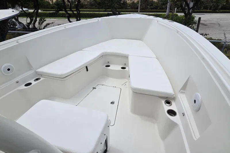 Slide: The Image of 2016 Sailfish 320 CC boat interior with white cushioned seating and cup holders. - 16