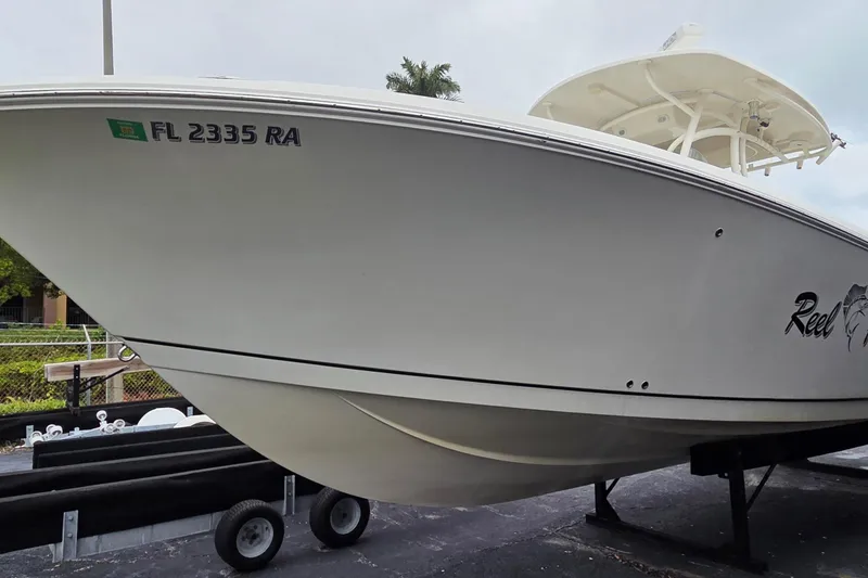 Slide: The Image of 2016 Sailfish 320 CC boat on trailer, side view with registration number FL 2335 RA. - 2
