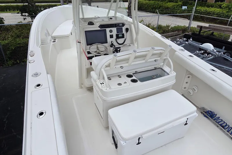 Slide: The Image of 2016 Sailfish 320 CC boat interior with white seating and storage compartments. - 4