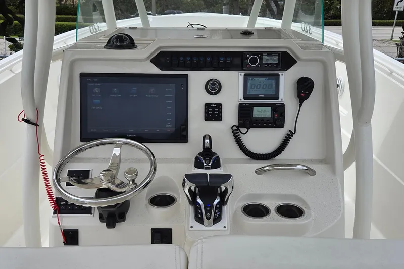 Slide: The Image of Control panel of a 2016 Sailfish 320 CC boat with steering wheel and navigation equipment. - 6