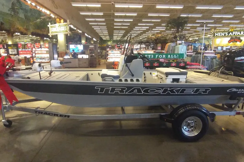 The Image of 2026 Tracker Bass Tracker Classic CC boat displayed indoors on a trailer. - 0