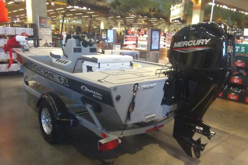 Slide: The Image of 2026 Tracker Bass Tracker Classic CC boat with Mercury engine displayed indoors. - 3