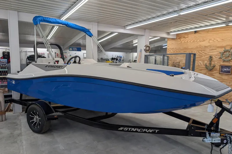 The Image of 2025 Starcraft SV 16 OB boat with blue hull on display in showroom. - 0