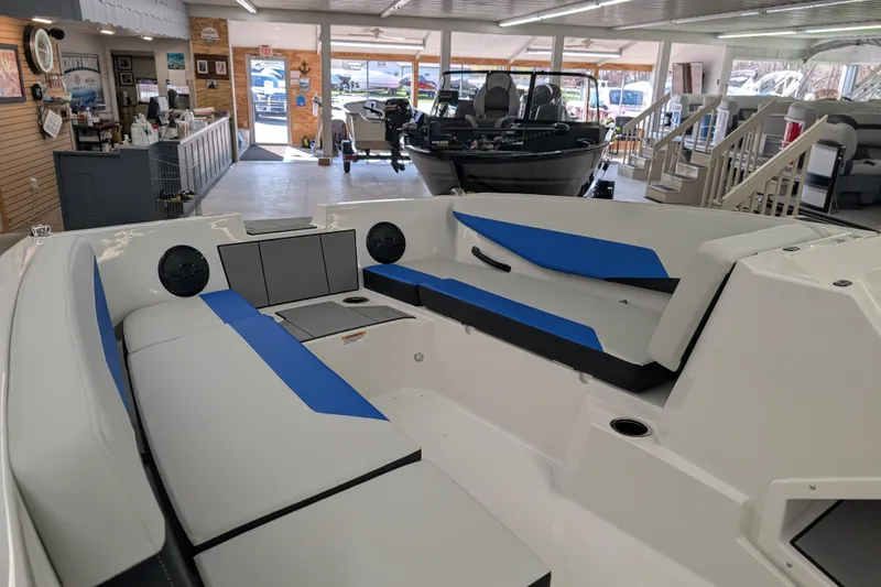 Slide: The Image of 2025 Starcraft SV 16 OB boat interior with blue and gray seating in showroom. - 10