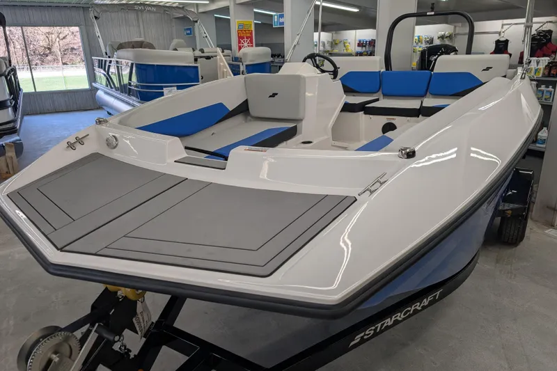 Slide: The Image of 2025 Starcraft SV 16 OB boat in showroom, featuring sleek design and blue seating. - 11