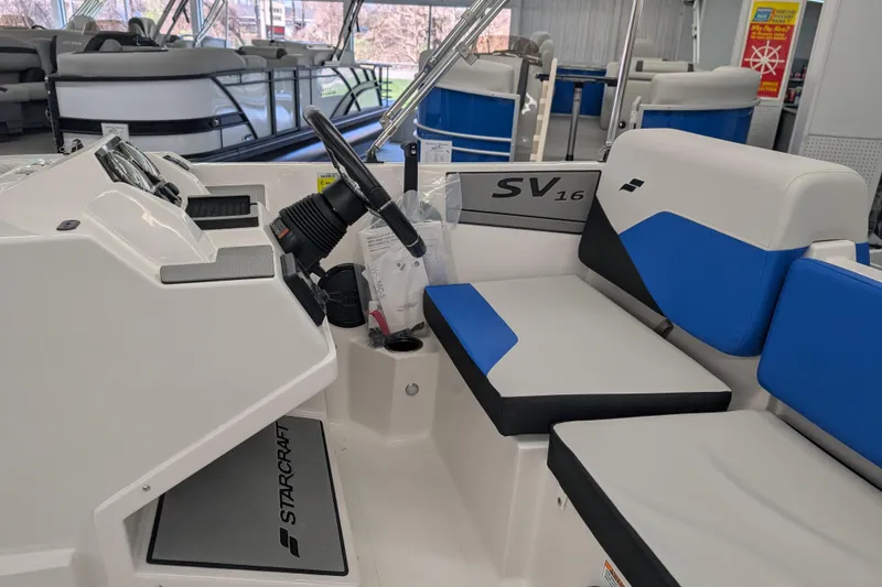 Slide: The Image of 2025 Starcraft SV 16 OB boat interior with steering wheel and blue seating. - 9