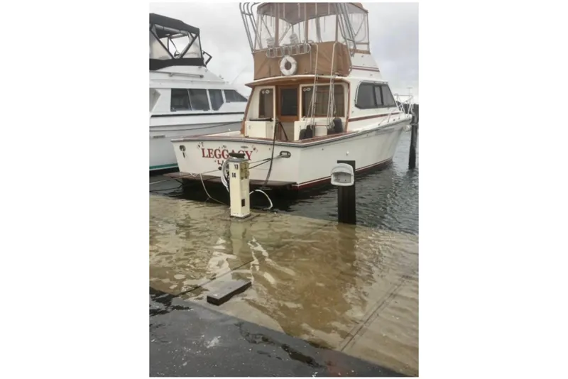 The Image of 1988 Egg Harbor 35 Sport Fisherman docked at marina, partially submerged pier. - 0