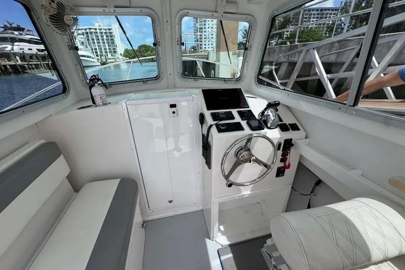 Slide: The Image of Interior of 2019 Steiger Craft 255 Miami boat, featuring helm and seating area. - 13