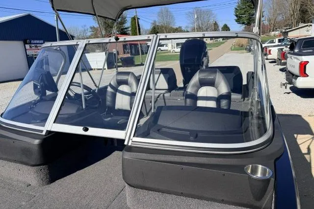 Slide: The Image of 2022 Crestliner 1750 Fish Hawk SE boat with windshield and seating, parked outdoors. - 18