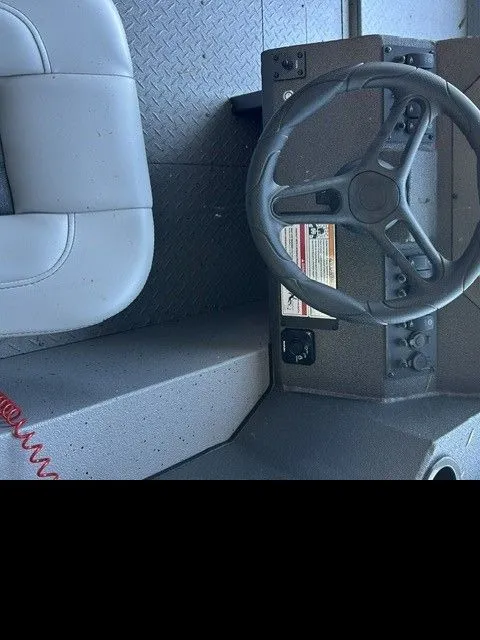 Slide: The Image of Interior view of SeaArk PROCAT 240 boat, steering area with gray wheel. - 11
