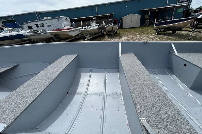 Slide: The Image of 2026 Crestliner 1672 Outreach boat interior with gray seating, parked among other boats. - 13