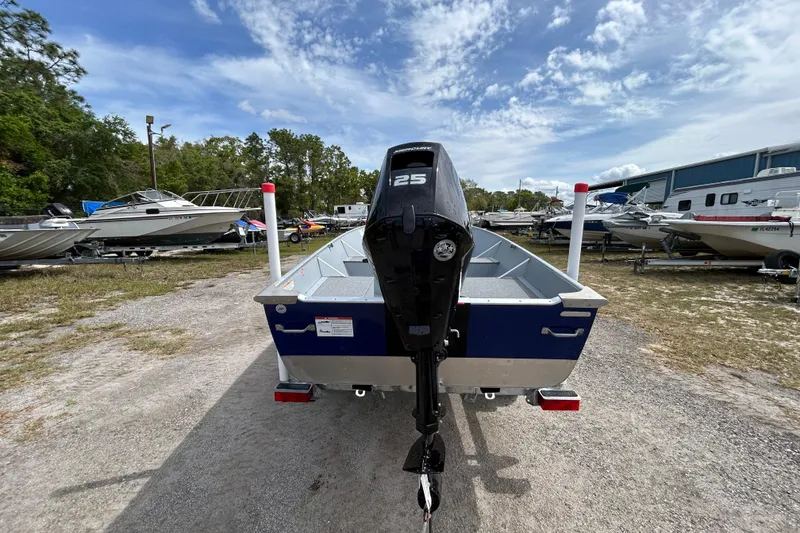 Slide: The Image of 2026 Crestliner 1672 Outreach boat with 25 HP motor, parked outdoors. - 3