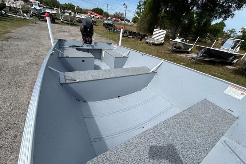 Slide: The Image of 2026 Crestliner 1672 Outreach boat, spacious interior, parked outdoors with other boats. - 6