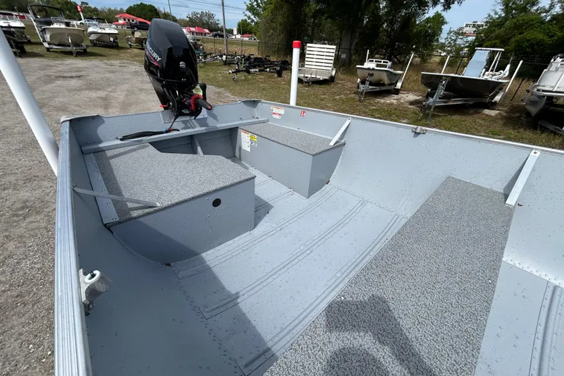 Slide: The Image of 2026 Crestliner 1672 Outreach boat interior with Mercury outboard motor, parked outdoors. - 7