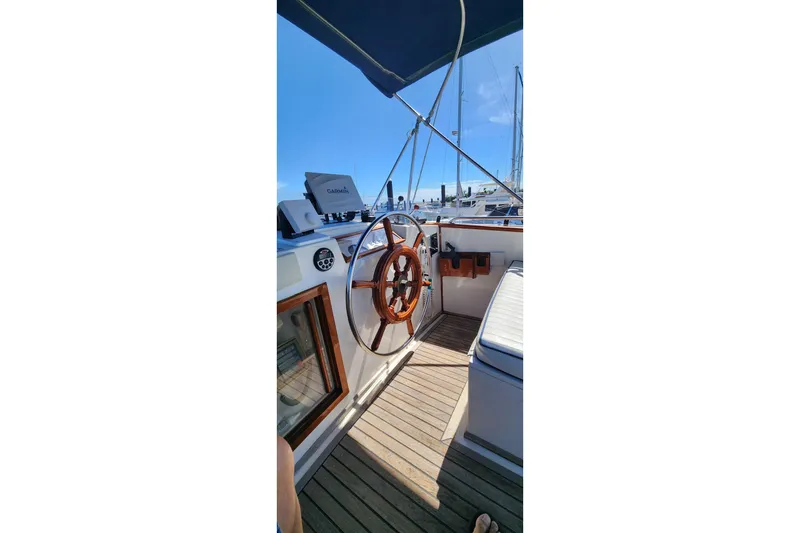 Slide: The Image of 1987 Grand Banks 36 Classic yacht helm with wooden wheel and Garmin navigation. - 12