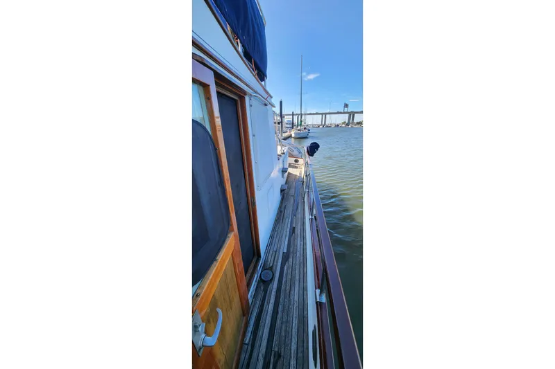 Slide: The Image of 1987 Grand Banks 36 Classic yacht docked, showcasing wooden deck and marina view. - 14