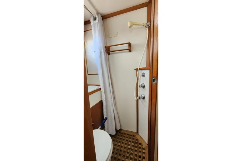 Slide: The Image of Shower area in 1987 Grand Banks 36 Classic boat with wooden accents and curtain. - 16