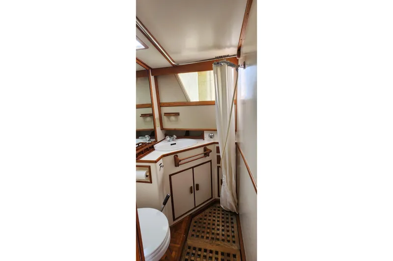 Slide: The Image of Bathroom interior of 1987 Grand Banks 36 Classic yacht, featuring wood accents and compact design. - 23