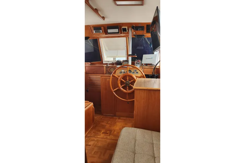 Slide: The Image of Interior helm of 1987 Grand Banks 36 Classic with wooden steering wheel and navigation equipment. - 27