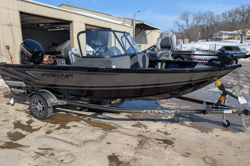 The Image of 2026 Starcraft Storm 176 DC Pro boat on trailer, parked outside a warehouse. - 0