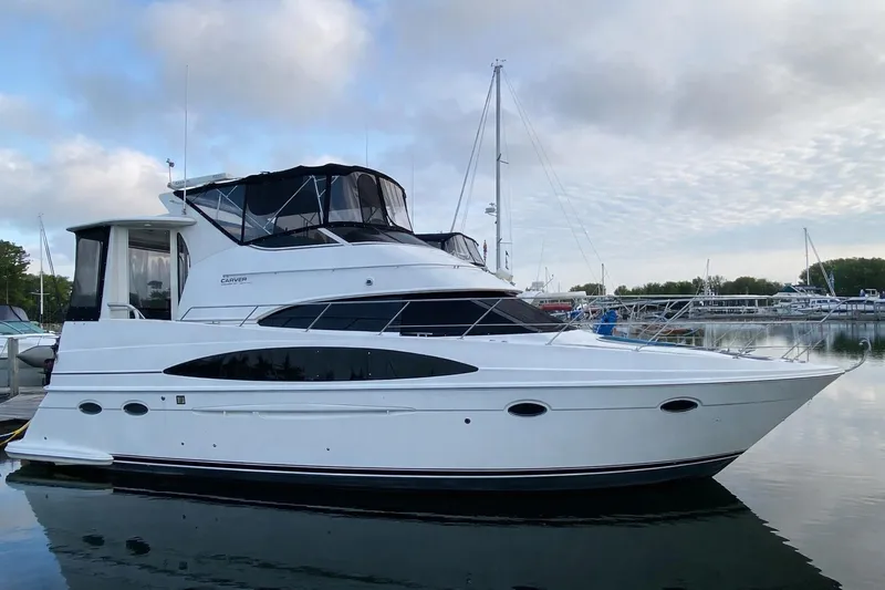 The Image of 2000 Carver 396 Motor Yacht docked in a serene marina setting. - 0