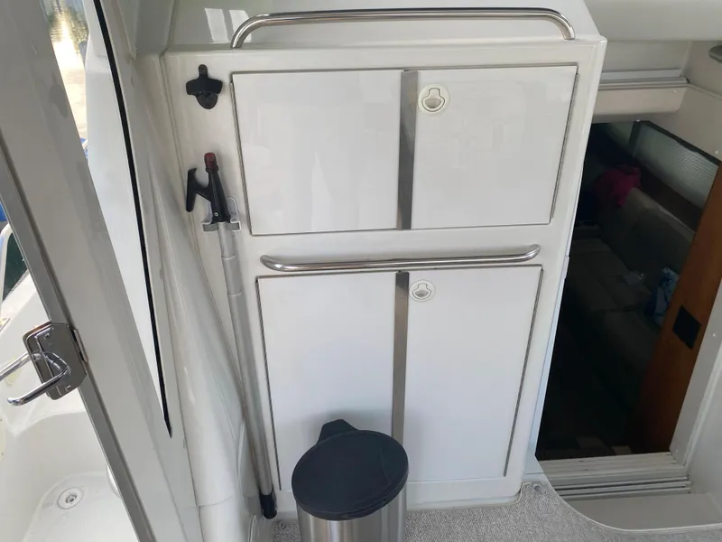 Slide: The Image of Interior of a 2000 Carver 396 Motor Yacht with storage cabinets and trash bin. - 12