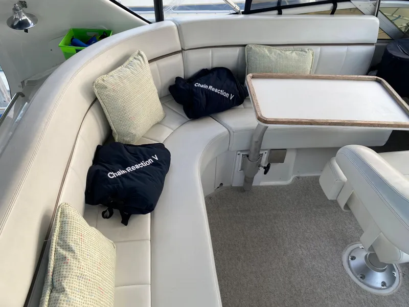 Slide: The Image of 2000 Carver 396 Motor Yacht interior seating area with cushions and table. - 16
